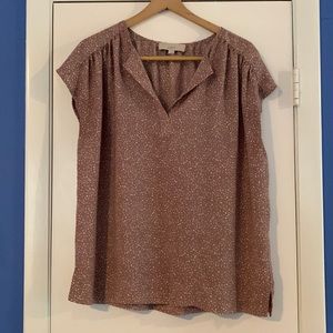 Sleeveless blouse with ruched shoulders. Neutral color with white specs